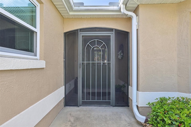 view of exterior entry featuring stucco siding