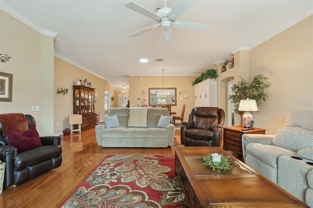 living room with wood finished floors, baseboards, arched walkways, ornamental molding, and ceiling fan with notable chandelier