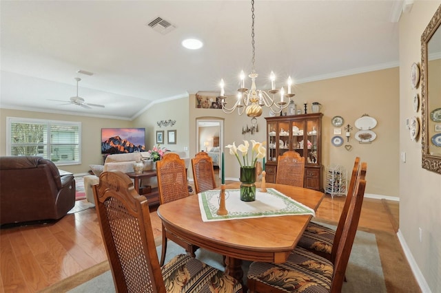 dining area featuring baseboards, visible vents, light wood finished floors, ornamental molding, and ceiling fan with notable chandelier