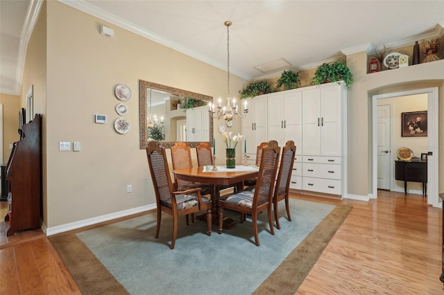 dining space with an inviting chandelier, light wood-style floors, baseboards, and ornamental molding