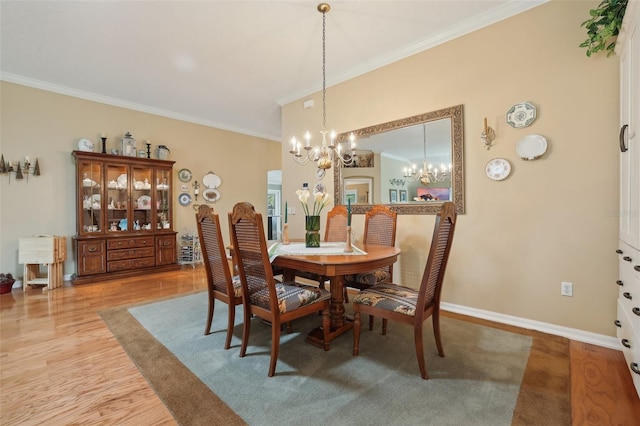 dining room with wood finished floors, baseboards, an inviting chandelier, and ornamental molding