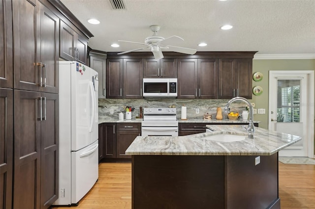 kitchen with a sink, electric range, light wood finished floors, and freestanding refrigerator