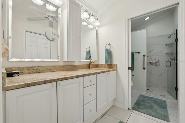 full bath with a marble finish shower, crown molding, toilet, vanity, and a ceiling fan