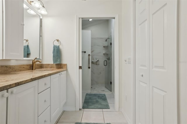 bathroom featuring vanity, tile patterned flooring, and a marble finish shower