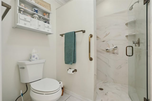 bathroom with a marble finish shower, toilet, and baseboards