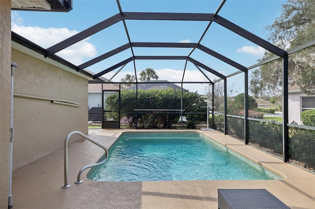 pool featuring glass enclosure and a patio area