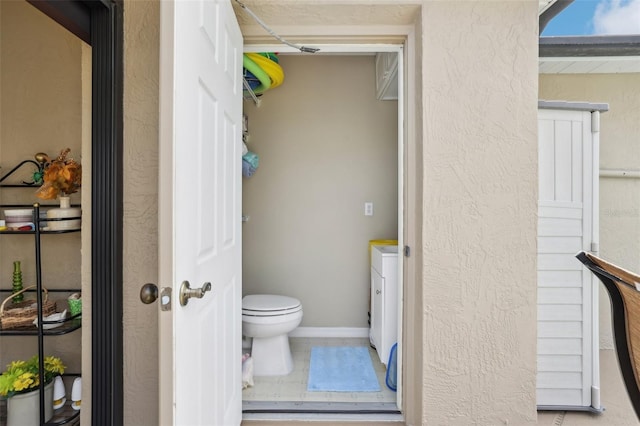 bathroom featuring tile patterned floors, toilet, and baseboards