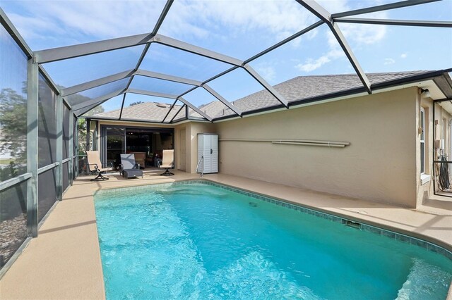 pool with glass enclosure and a patio