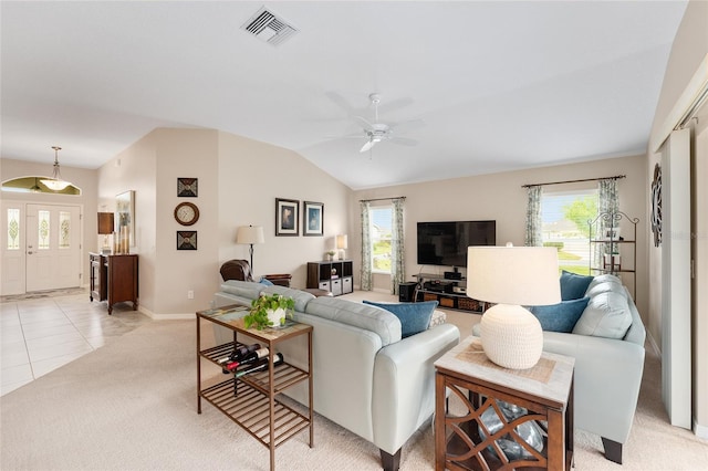 living area featuring ceiling fan, light tile patterned floors, light colored carpet, visible vents, and vaulted ceiling