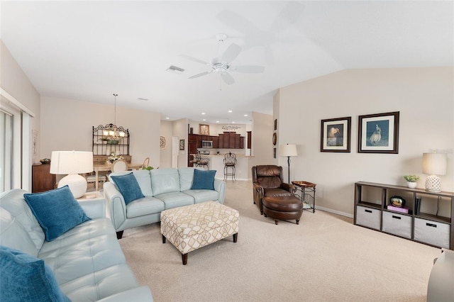 living area with visible vents, light carpet, vaulted ceiling, baseboards, and ceiling fan with notable chandelier