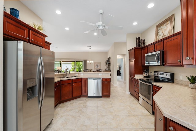 kitchen with light countertops, appliances with stainless steel finishes, a sink, dark brown cabinets, and a peninsula