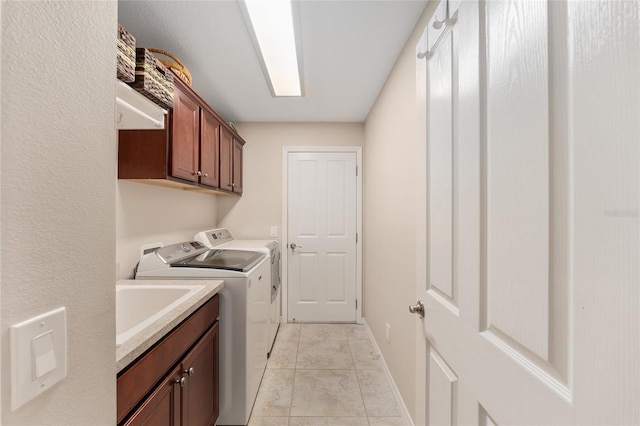 laundry room with baseboards, light tile patterned flooring, cabinet space, and washer and dryer