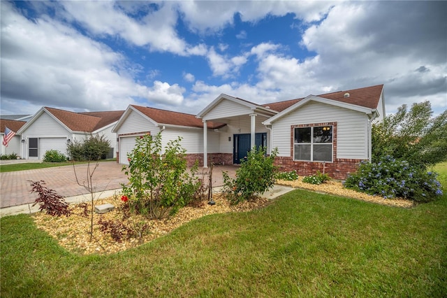 ranch-style home featuring an attached garage, brick siding, decorative driveway, and a front yard