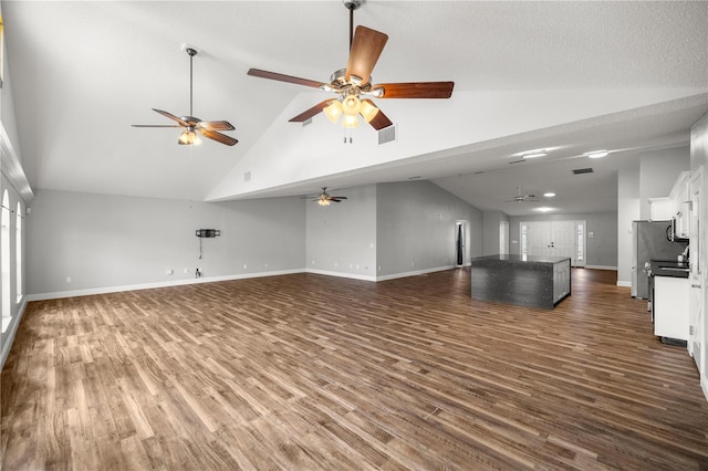 unfurnished living room featuring ceiling fan, high vaulted ceiling, dark wood-style flooring, visible vents, and baseboards