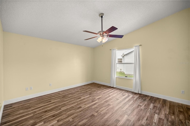 empty room featuring ceiling fan, a textured ceiling, wood finished floors, baseboards, and vaulted ceiling