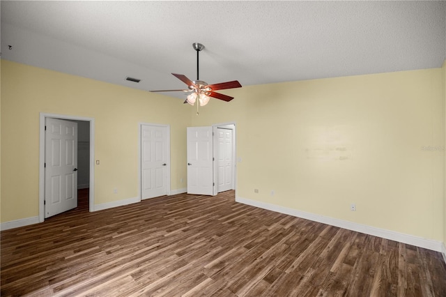 unfurnished bedroom featuring vaulted ceiling, wood finished floors, visible vents, and baseboards