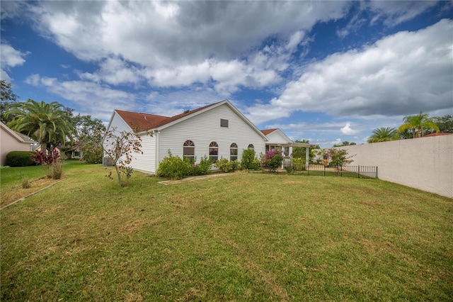 exterior space with fence and a lawn