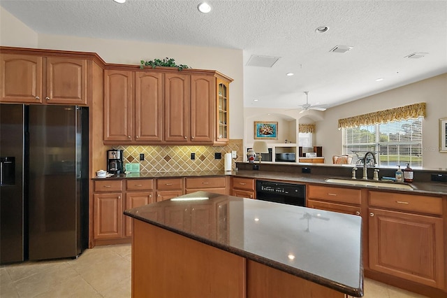 kitchen featuring tasteful backsplash, dishwasher, brown cabinets, stainless steel refrigerator with ice dispenser, and a sink