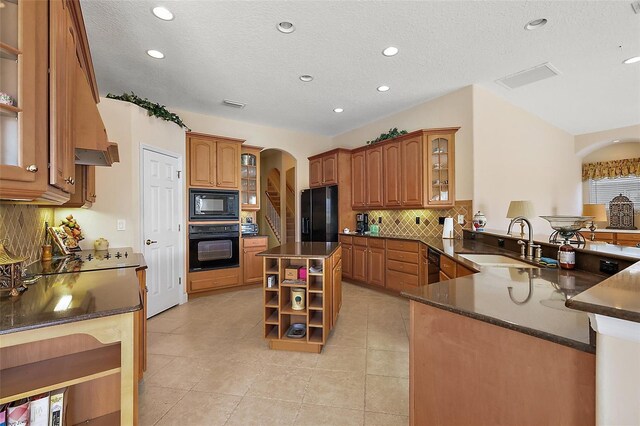 kitchen with arched walkways, black appliances, open shelves, a sink, and light tile patterned flooring