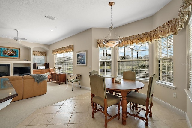 dining room featuring a textured ceiling, ceiling fan, visible vents, and baseboards