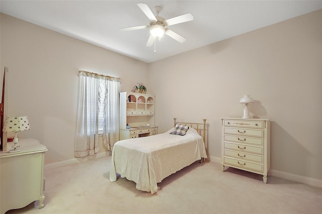 bedroom featuring a ceiling fan, light carpet, and baseboards