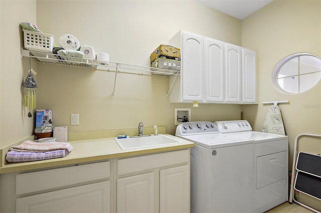 washroom featuring independent washer and dryer, a sink, and cabinet space