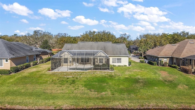 back of house featuring a lanai, a patio area, and a yard