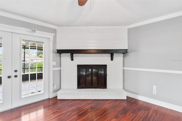 unfurnished living room featuring a brick fireplace, baseboards, ornamental molding, and wood finished floors