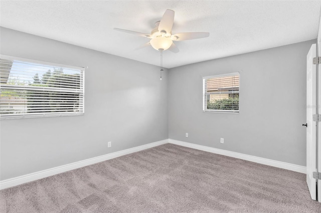 unfurnished room with carpet floors, ceiling fan, baseboards, and a textured ceiling