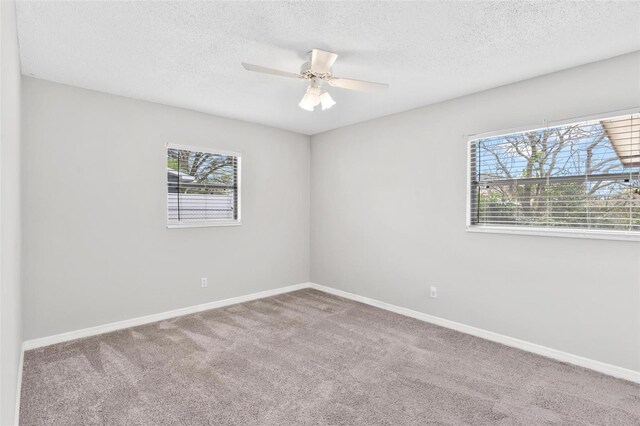 spare room featuring carpet floors, ceiling fan, baseboards, and a textured ceiling