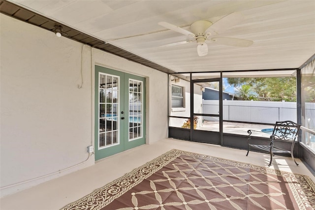 unfurnished sunroom with a ceiling fan and french doors