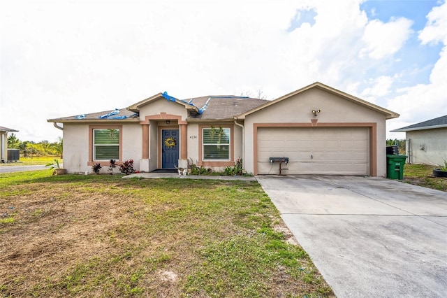 ranch-style house featuring a garage, a front yard, concrete driveway, and stucco siding