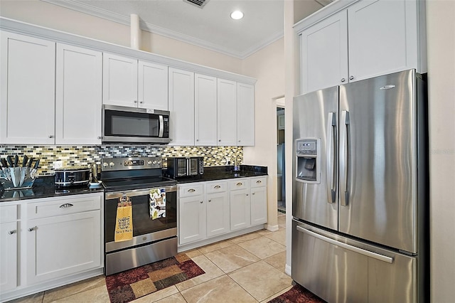 kitchen with ornamental molding, appliances with stainless steel finishes, dark countertops, and decorative backsplash