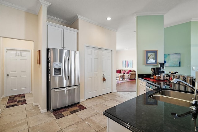 kitchen with ornamental molding, stainless steel fridge, a sink, and light tile patterned floors