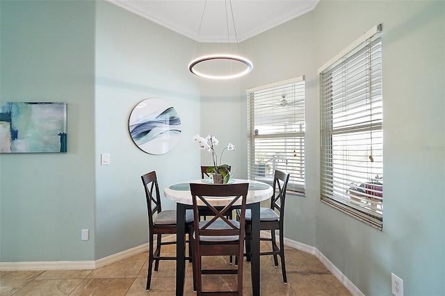 tiled dining area with crown molding and baseboards