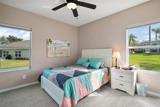 bedroom with light carpet, baseboards, and a ceiling fan