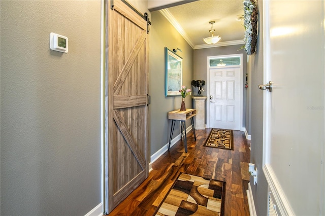 doorway to outside featuring a barn door, baseboards, dark wood finished floors, and crown molding