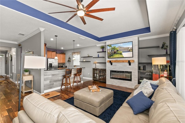 living area with visible vents, ornamental molding, and dark wood-style flooring