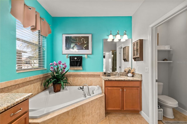 full bathroom featuring vanity, a garden tub, toilet, and tile patterned floors