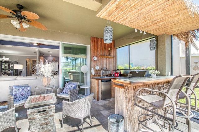 view of patio featuring outdoor dry bar, an outdoor fire pit, and ceiling fan