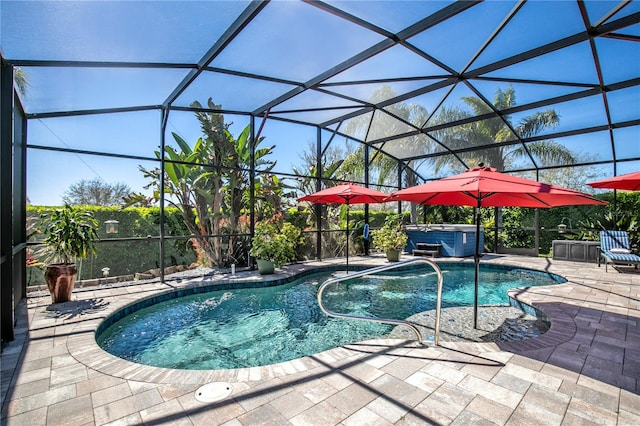 outdoor pool with glass enclosure, a patio area, and a hot tub