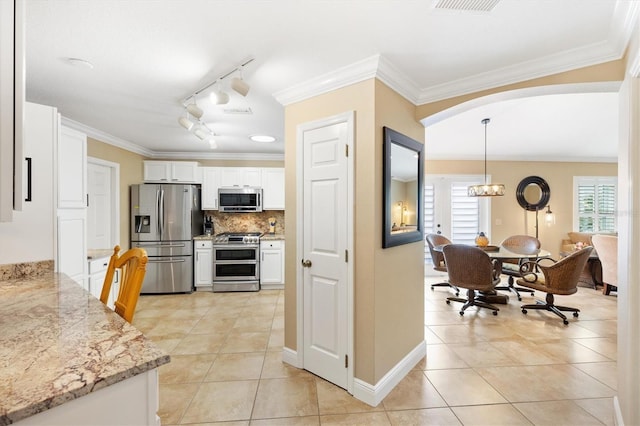 kitchen featuring an inviting chandelier, plenty of natural light, stainless steel appliances, and crown molding