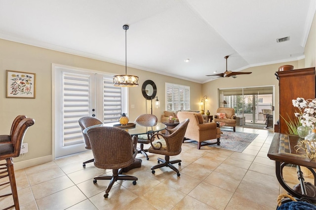 dining space with ceiling fan, light tile patterned flooring, baseboards, vaulted ceiling, and crown molding