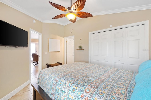 bedroom with light tile patterned floors, ornamental molding, a closet, and baseboards