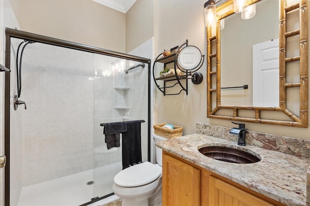 full bathroom featuring ornamental molding, a stall shower, vanity, and toilet