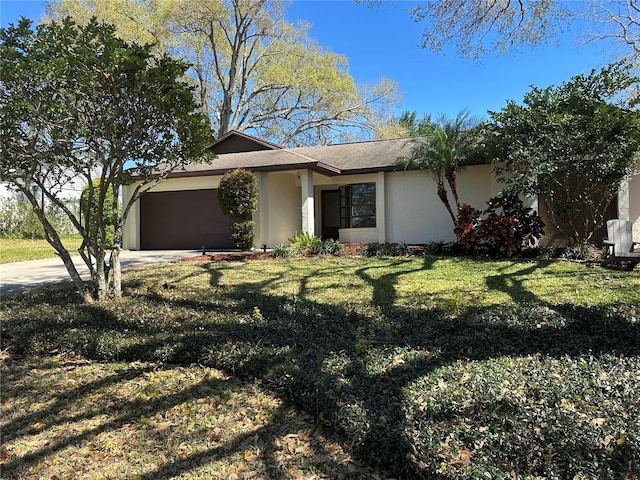 view of front of house with driveway, a front lawn, an attached garage, and stucco siding