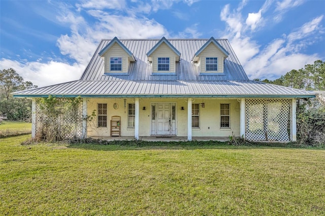 farmhouse inspired home featuring stucco siding, a porch, a front yard, and metal roof