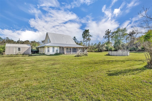 back of house with a lawn and metal roof