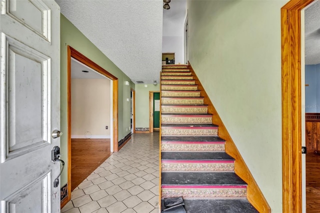 stairs with a textured ceiling