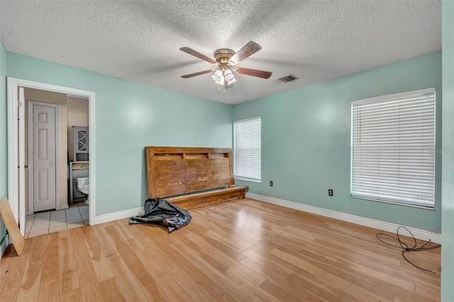 bedroom featuring wood finished floors, baseboards, and a textured ceiling